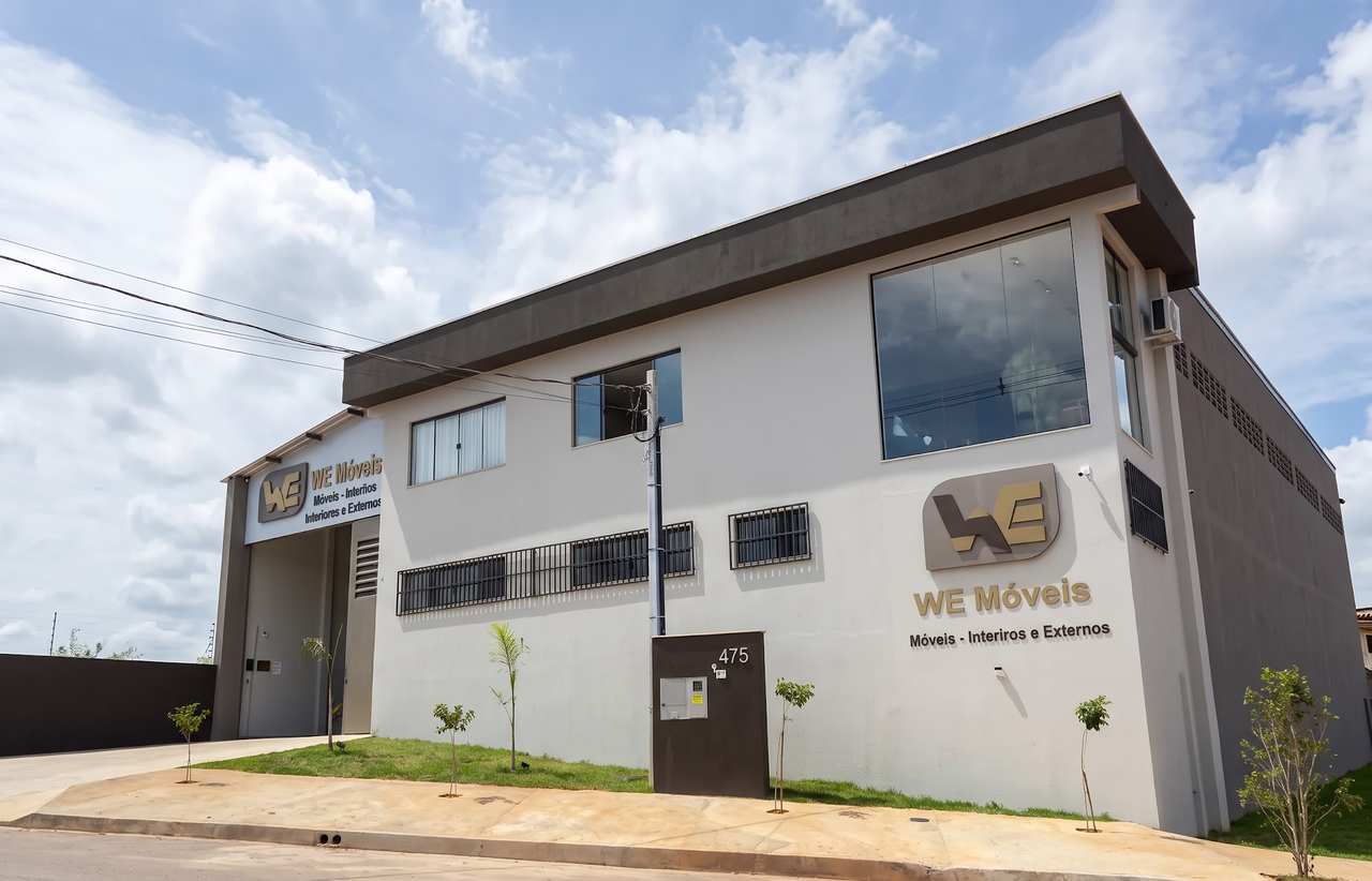 Fachada da fábrica da WE Móveis em Cláudio, Minas Gerais, com a placa da empresa