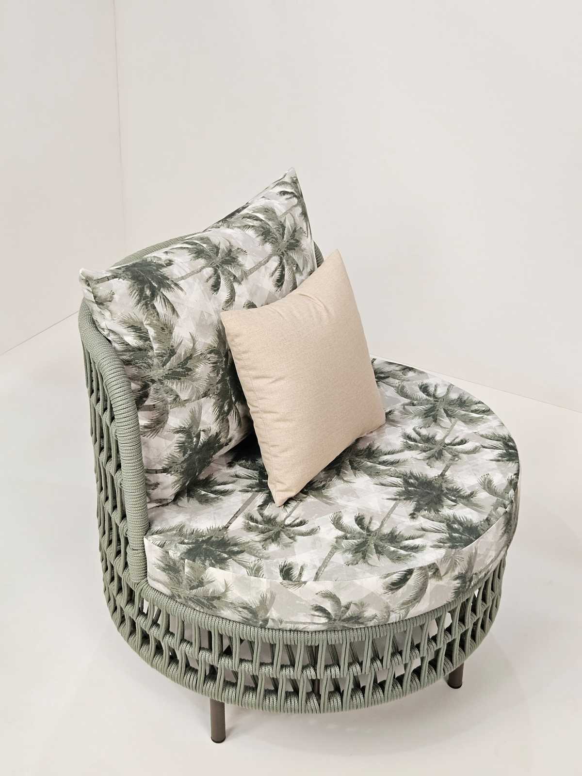Poltrona redonda com trama clara e almofada de estampa floral